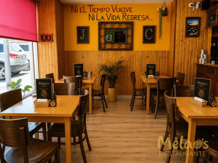Salón principal de Melao’s con mesas de madera y decoración colombiana