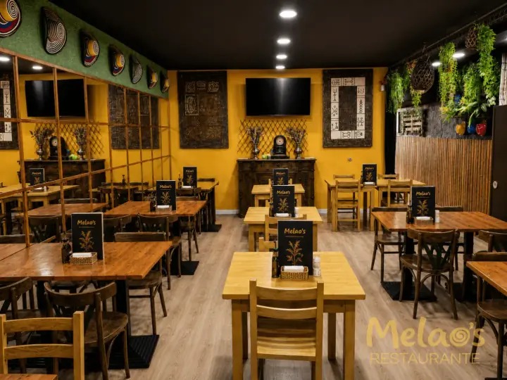Comedor interior de Melao’s con mesas preparadas y plantas colgantes